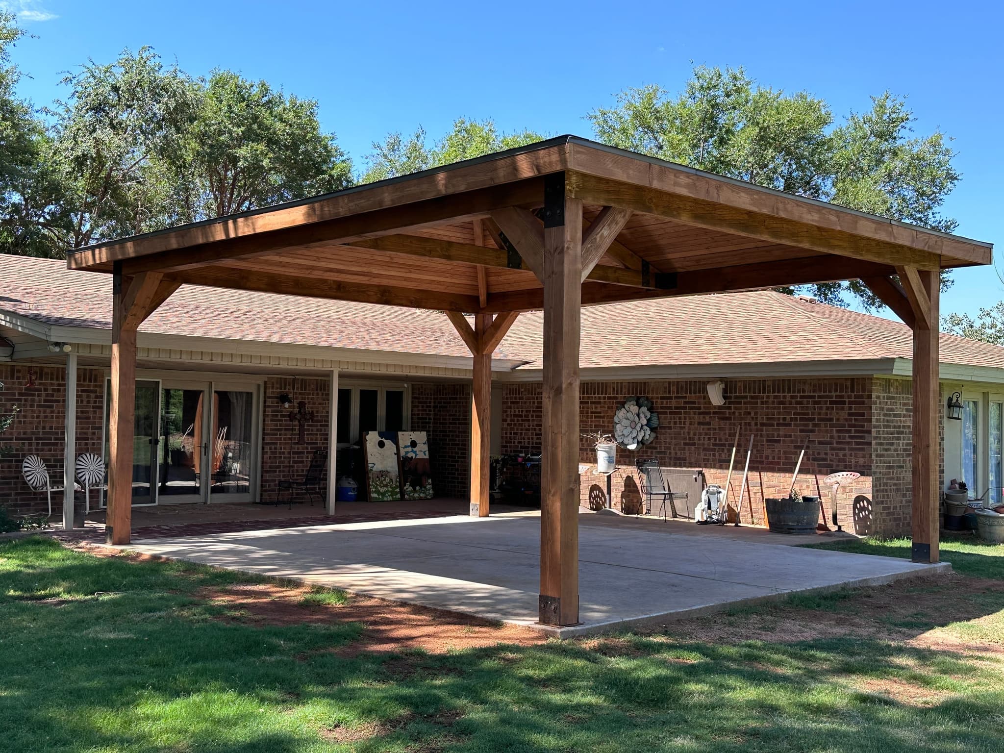 Hip-roofed timber pavilion built off a brick ranch house