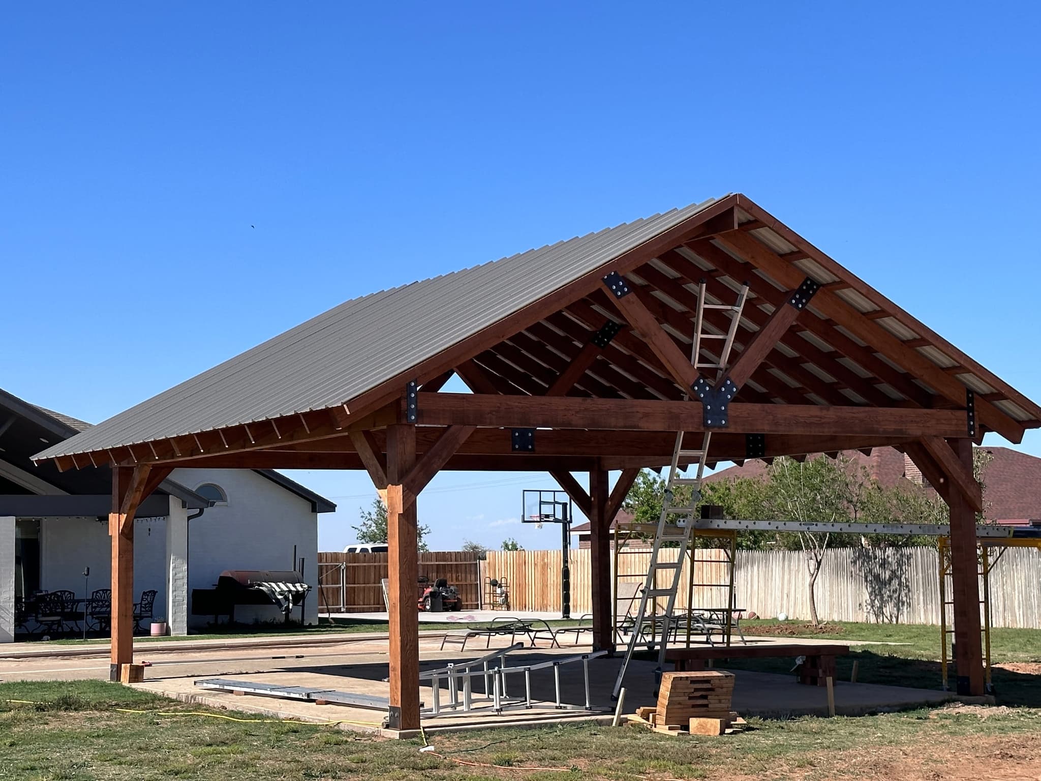 Finished Nichols pavilion — hewn timber frame under a metal panel roof